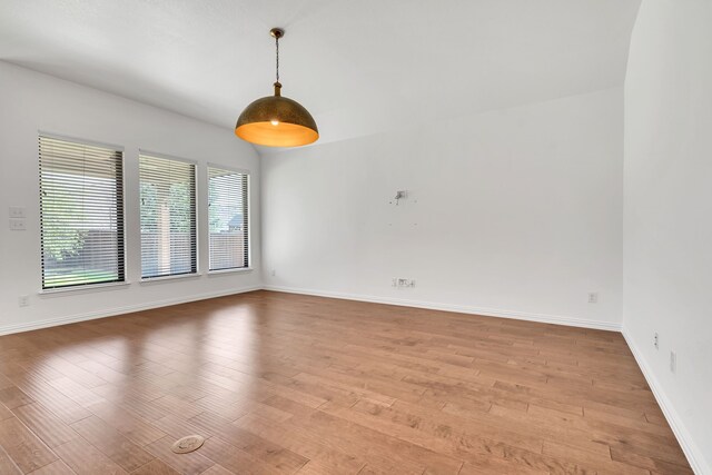 spare room with baseboards and light wood-type flooring
