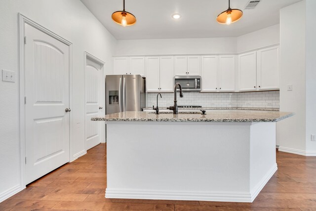 kitchen featuring wood finished floors, visible vents, stainless steel appliances, and white cabinets