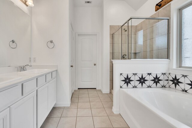 full bathroom featuring a sink, tile patterned floors, a stall shower, double vanity, and a garden tub