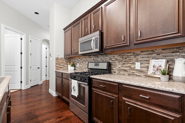 4717 Whitehall Ct, Mckinney, TX 75070 - kitchen with stainless steel appliances, tasteful backsplash, dark wood-style floors, dark brown cabinets, and light stone countertops