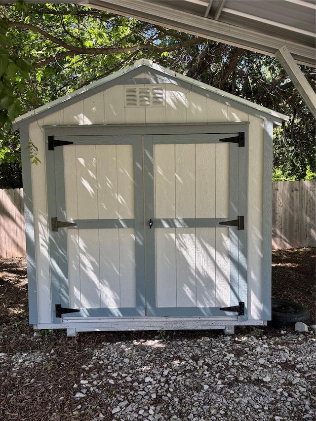 view of shed featuring fence