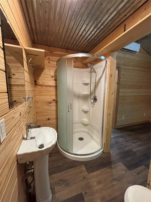 bathroom with wooden walls, a shower stall, wood ceiling, and wood finished floors