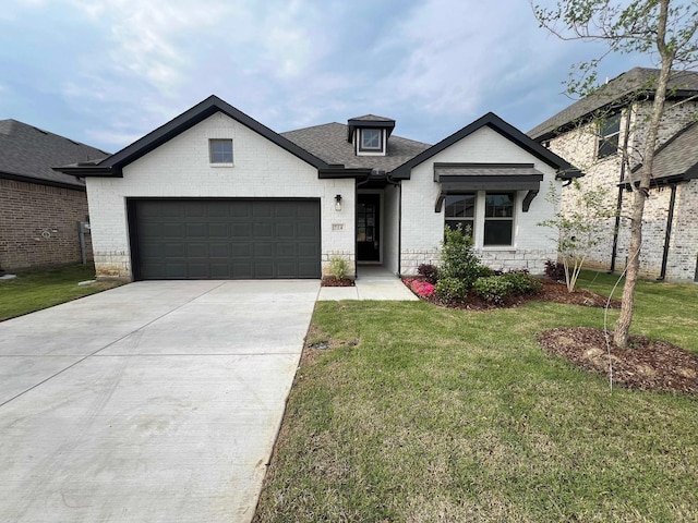 view of front of property featuring a shingled roof, a front lawn, concrete driveway, an attached garage, and brick siding