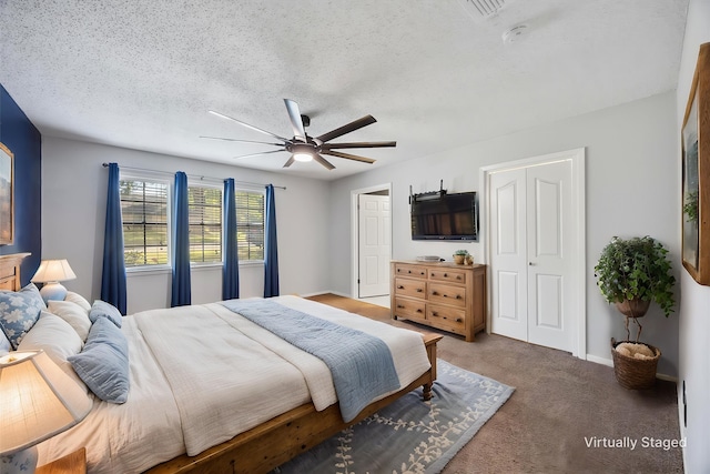 carpeted bedroom with baseboards, a ceiling fan, a textured ceiling, and a closet