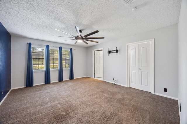 carpeted spare room with baseboards, ceiling fan, and a textured ceiling