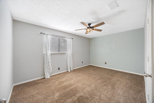 carpeted spare room with baseboards, a ceiling fan, a textured ceiling, and visible vents