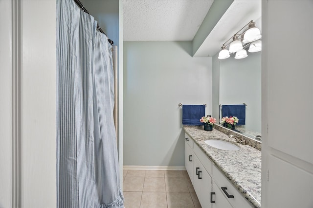 full bath with tile patterned flooring, baseboards, vanity, and a textured ceiling
