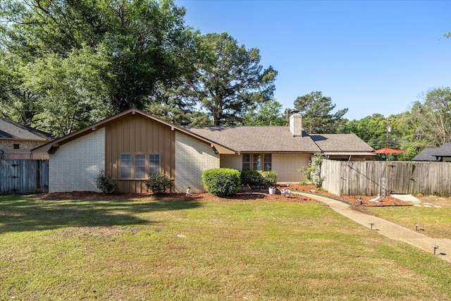 view of front of house featuring brick siding, a chimney, and fence