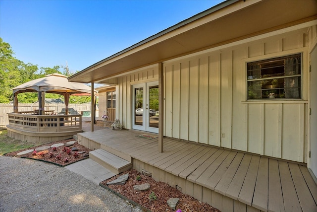 wooden deck with a gazebo, fence, and french doors