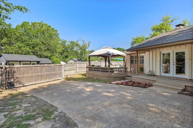 view of yard featuring fence, a wooden deck, french doors, and a gazebo
