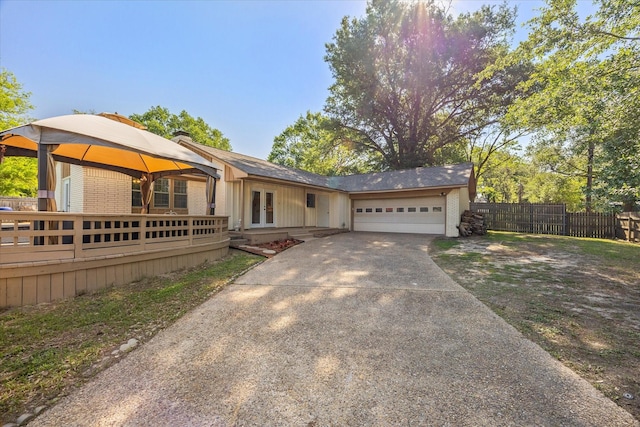 ranch-style house featuring brick siding, fence, a garage, driveway, and french doors