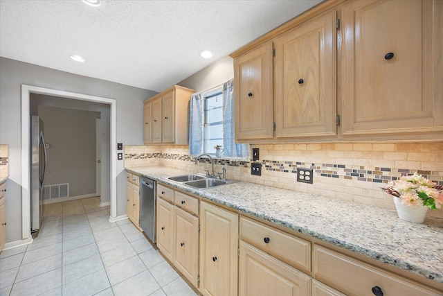 kitchen with light brown cabinetry, a sink, visible vents, baseboards, and appliances with stainless steel finishes