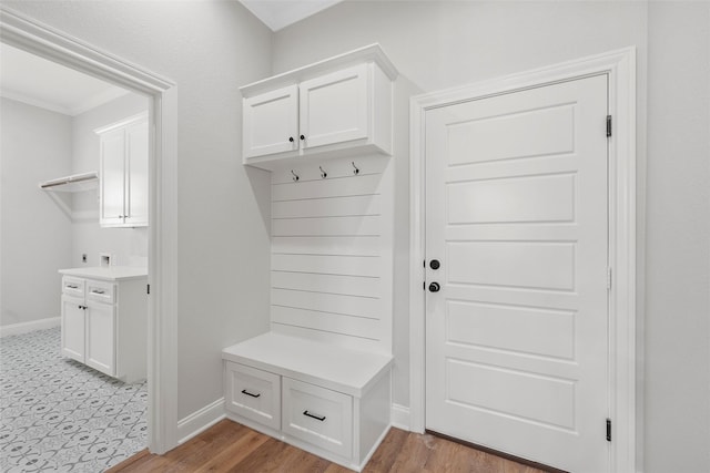 mudroom featuring light wood-style flooring, baseboards, and ornamental molding