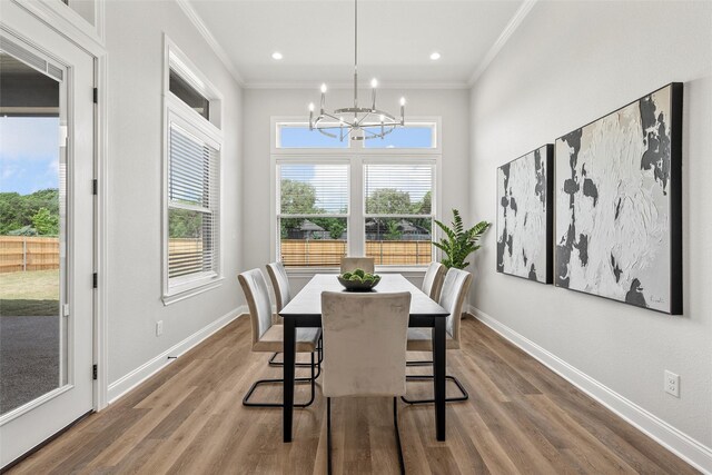 dining space with baseboards, wood finished floors, an inviting chandelier, and ornamental molding