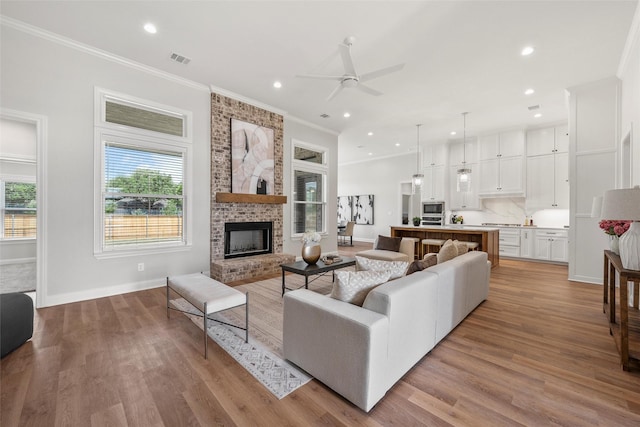 living area featuring a fireplace, a ceiling fan, visible vents, and recessed lighting