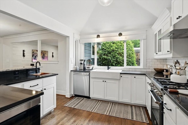 kitchen featuring appliances with stainless steel finishes, tasteful backsplash, white cabinets, and a sink