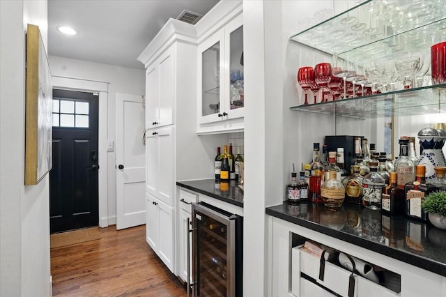 bar featuring visible vents, wine cooler, a dry bar, recessed lighting, and wood finished floors