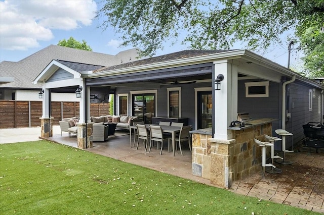 rear view of house with a patio, outdoor dry bar, fence, a yard, and an outdoor living space