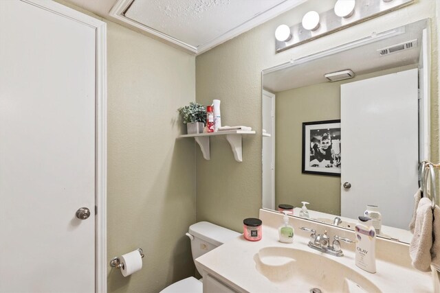 half bath featuring toilet, vanity, and visible vents
