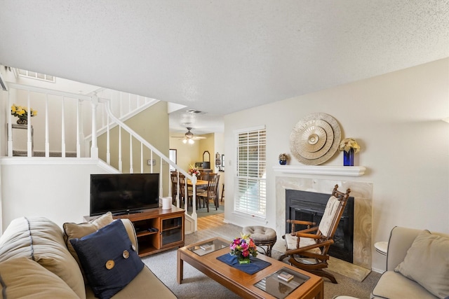 living area with visible vents, a fireplace, carpet, a ceiling fan, and stairs