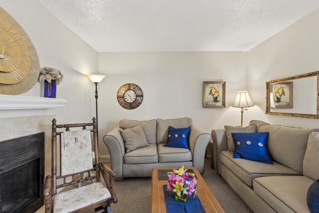 carpeted living room featuring a fireplace and a textured ceiling