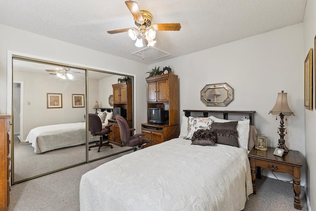 bedroom with visible vents, a closet, carpet floors, attic access, and a ceiling fan
