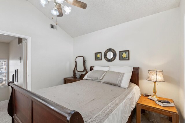 carpeted bedroom with visible vents, a ceiling fan, and vaulted ceiling