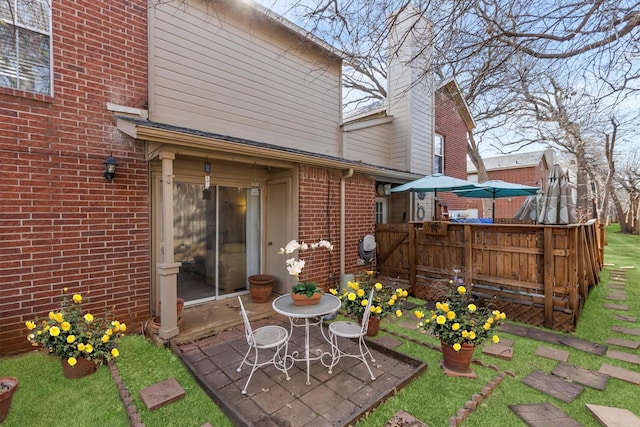 back of property featuring a patio, brick siding, and fence