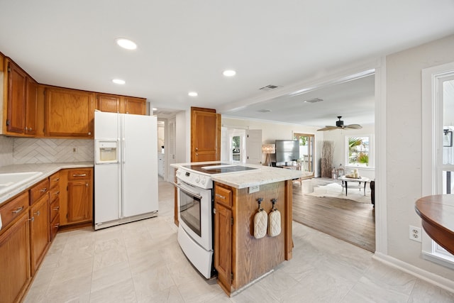 6725 Cahoba Dr, Fort Worth, TX 76135 - kitchen featuring brown cabinets, white appliances, light countertops, recessed lighting, and a kitchen island