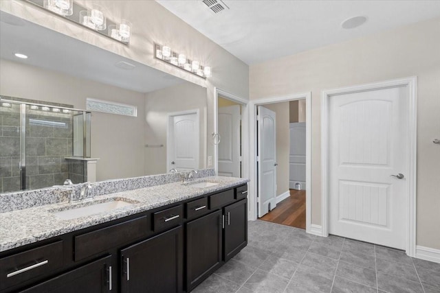 6514 Eagle Rock Dr, Frisco, TX 75036 - full bath with double vanity, visible vents, tiled shower, and a sink
