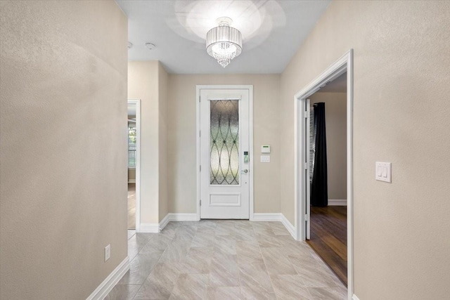 6514 Eagle Rock Dr, Frisco, TX 75036 - foyer entrance with a textured wall, baseboards, and a notable chandelier