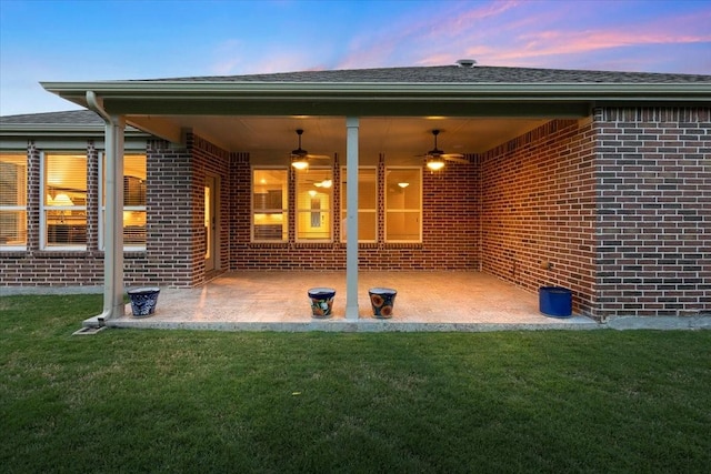 6514 Eagle Rock Dr, Frisco, TX 75036 - back of property at dusk with brick siding, a ceiling fan, a lawn, and a patio