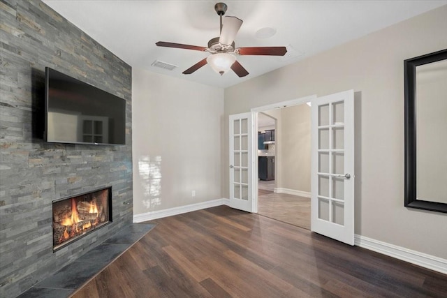 6514 Eagle Rock Dr, Frisco, TX 75036 - unfurnished living room with wood finished floors, visible vents, a ceiling fan, french doors, and a large fireplace
