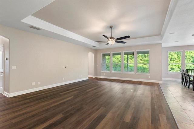 6514 Eagle Rock Dr, Frisco, TX 75036 - unfurnished living room with a ceiling fan, arched walkways, a tray ceiling, baseboards, and visible vents