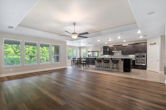 6514 Eagle Rock Dr, Frisco, TX 75036 - living room with baseboards, wood finished floors, a tray ceiling, and visible vents
