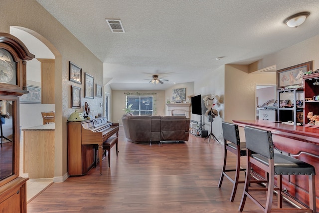 6121 Bowfin Dr, Fort Worth, TX 76179 - living room with a textured ceiling, wood finished floors, visible vents, and ceiling fan