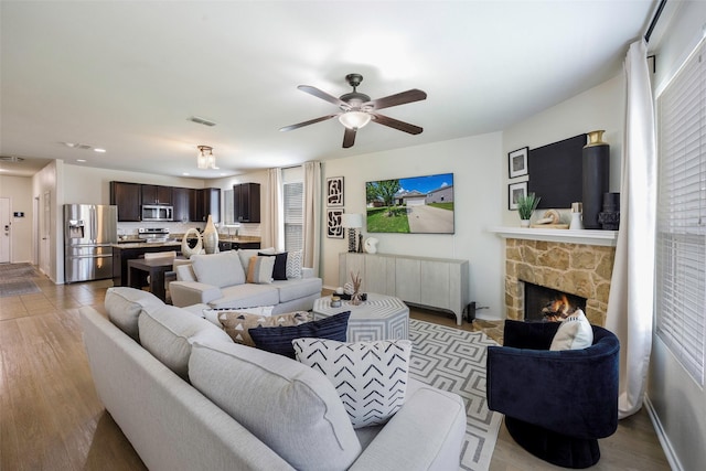 3011 Whispering Pine Blvd, Melissa, TX 75454 - living area featuring radiator heating unit, a ceiling fan, recessed lighting, a stone fireplace, and wood finished floors