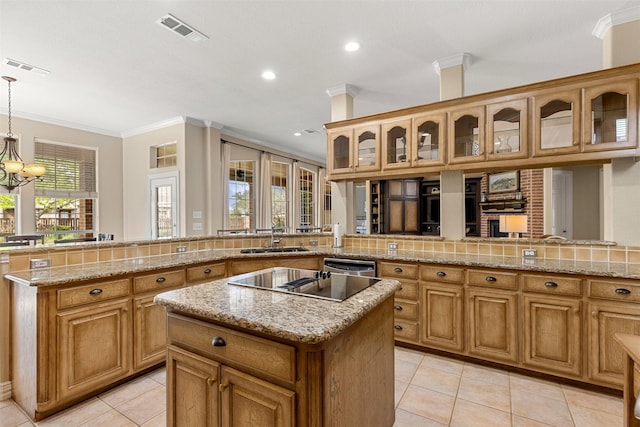 kitchen with a center island, a sink, visible vents, crown molding, and light tile patterned floors