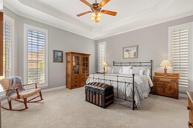 bedroom with a raised ceiling, ornamental molding, carpet floors, baseboards, and ceiling fan