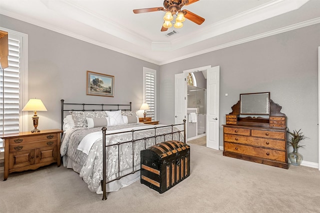 carpeted bedroom featuring a tray ceiling, visible vents, baseboards, a ceiling fan, and ornamental molding