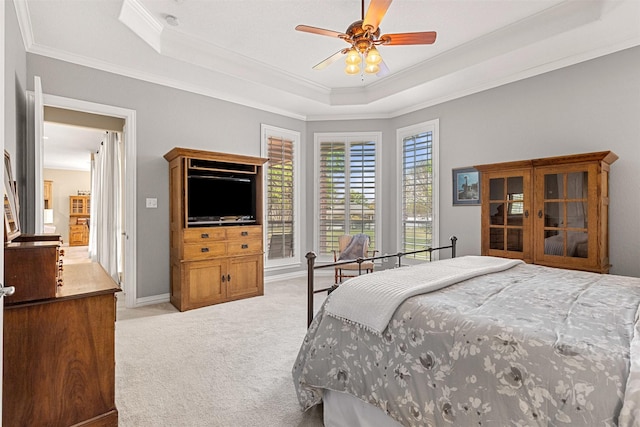 bedroom with ceiling fan, light carpet, ornamental molding, and a raised ceiling