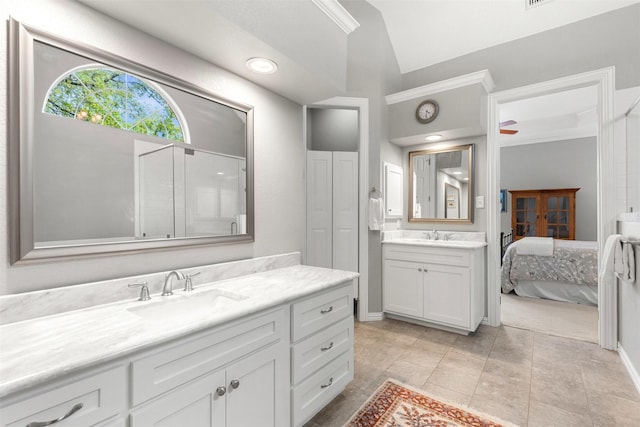 ensuite bathroom featuring lofted ceiling, an enclosed shower, vanity, and ensuite bathroom