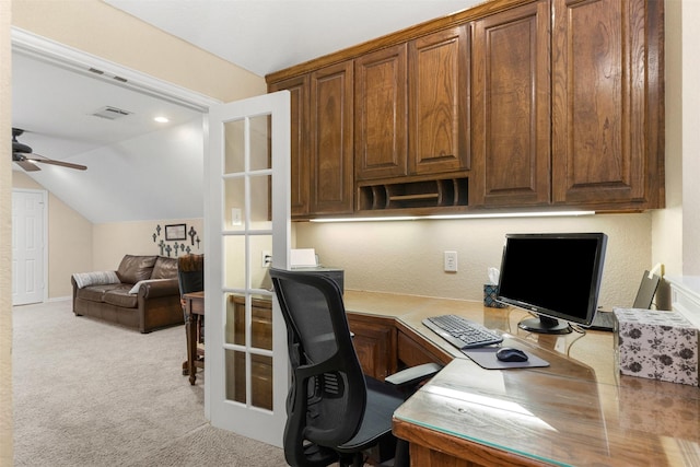 carpeted home office with vaulted ceiling, visible vents, and a ceiling fan