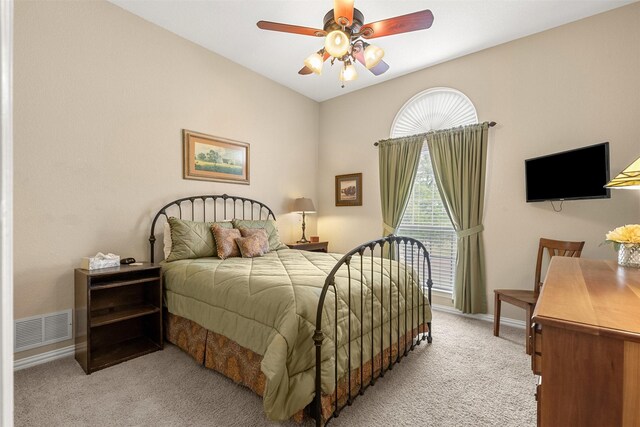 bedroom with baseboards, a ceiling fan, visible vents, and light colored carpet