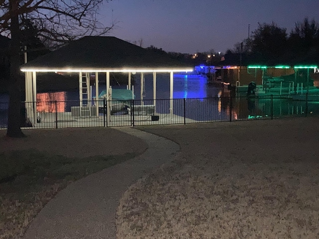 view of front of property featuring fence and a water view