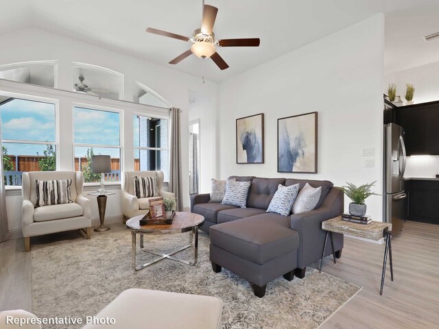 living room featuring light wood-type flooring, visible vents, and ceiling fan