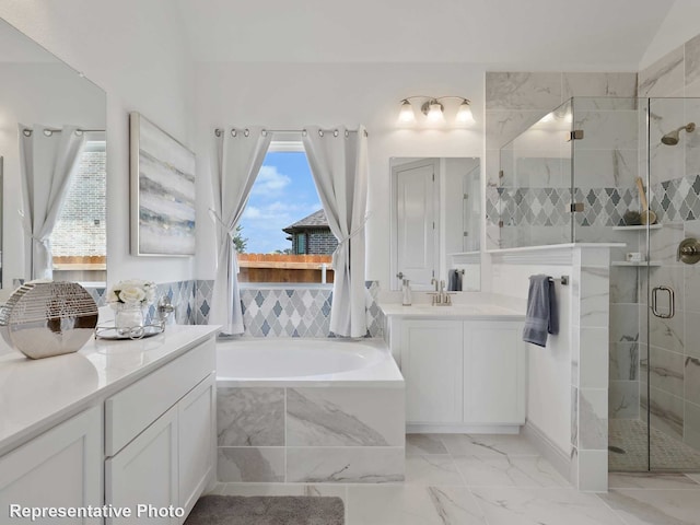 full bathroom featuring a shower stall, a garden tub, marble finish floor, and vanity