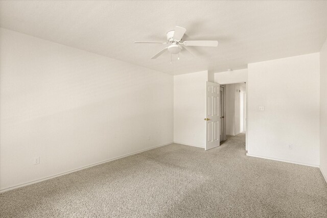 unfurnished room featuring baseboards, light colored carpet, and ceiling fan
