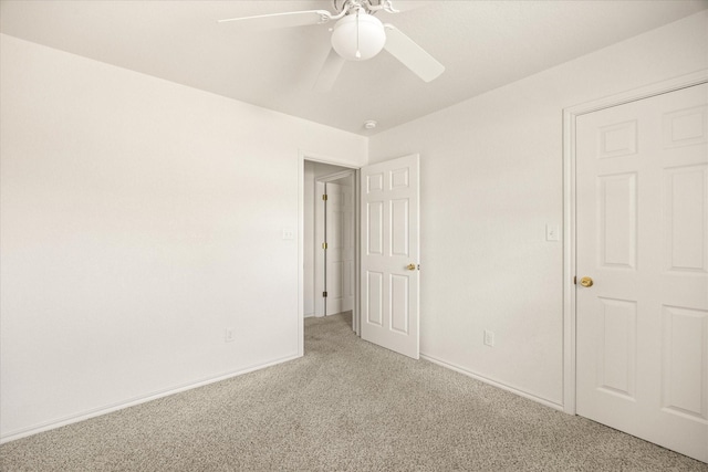 unfurnished bedroom featuring light carpet, a ceiling fan, and baseboards