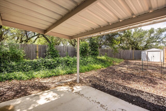 view of yard with a fenced backyard, an outbuilding, a patio area, and a storage unit